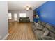 Bright living room with wood floors, a ceiling fan, and a vibrant accent wall at 10162 Benton Woods Dr, Covington, GA 30014