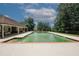 Community pool surrounded by lush greenery, with a covered lounge area for relaxation and sunbathing at 10162 Benton Woods Dr, Covington, GA 30014