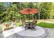 Outdoor patio with table set and umbrella, creating a perfect setting for outdoor dining and enjoying the serene backyard at 1127 Oak Hollow Ct, Hampton, GA 30228