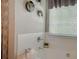 Bright bathroom featuring a tiled tub, shower with curtain, and decorative wall accents at 1127 Oak Hollow Ct, Hampton, GA 30228