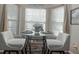 Charming dining area featuring a glass table, plush chairs, and bright natural light from the bay window at 1127 Oak Hollow Ct, Hampton, GA 30228