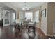 Cozy dining area featuring a glass table, chairs and bright natural light from the bay window and hardwood floors at 1127 Oak Hollow Ct, Hampton, GA 30228
