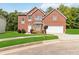 Charming two-story brick home with a well-manicured lawn and attached two-car garage at 1127 Oak Hollow Ct, Hampton, GA 30228