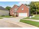 Well-maintained two-story brick home with a spacious driveway and lush green lawn at 1127 Oak Hollow Ct, Hampton, GA 30228