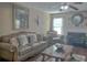 Cozy living room with a fireplace, ceiling fan, and elegant furniture at 1127 Oak Hollow Ct, Hampton, GA 30228