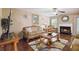 Cozy living room with a fireplace, ceiling fan, and elegant furniture at 1127 Oak Hollow Ct, Hampton, GA 30228