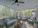 Relaxing screened-in porch with ample seating, curtains, and a ceiling fan for comfortable outdoor living at 1127 Oak Hollow Ct, Hampton, GA 30228