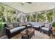 Well appointed screened-in porch with plenty of comfortable seating, an ideal space for relaxation and entertaining at 1127 Oak Hollow Ct, Hampton, GA 30228