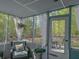 Charming screened-in porch featuring outdoor seating and curtains, offering a peaceful view of the surrounding greenery at 1127 Oak Hollow Ct, Hampton, GA 30228