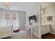 Bedroom with an attached, well-lit bathroom, desk with modern clear chair, and large windows with custom shades at 1199 Kenway Se Cir, Smyrna, GA 30082