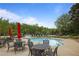 Community swimming pool surrounded by comfortable lounge chairs, tables with chairs, and red umbrellas at 1199 Kenway Se Cir, Smyrna, GA 30082