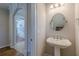 A powder room featuring a pedestal sink and a round mirror with neutral paint at 1303 Hill Se St, Atlanta, GA 30315