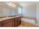 A luxurious bathroom features a dual sink vanity, granite counters, and a soaking tub at 1303 Hill Se St, Atlanta, GA 30315