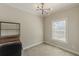 Bedroom with light colored carpet and walls, updated lighting fixture and large window at 1303 Hill Se St, Atlanta, GA 30315