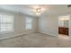 A neutral-toned bedroom features soft carpeting, natural light from two windows, and a lighted ceiling fan at 1303 Hill Se St, Atlanta, GA 30315