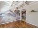 Dining room with an ornate chandelier, hardwood floors, a modern mural, and open kitchen at 1303 Hill Se St, Atlanta, GA 30315