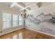 Sunlit dining area with hardwood floors, a mural wall, and a decorative light fixture at 1303 Hill Se St, Atlanta, GA 30315