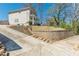 A side view of the home with retaining wall and paved driveway on a sunny day at 1303 Hill Se St, Atlanta, GA 30315