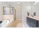 Bright bathroom featuring a bathtub, shower with glass, and long vanity with a mirror at 1525 Camden Cove Dr, Cumming, GA 30040