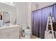 Bright bathroom featuring a sink, toilet, vanity and shower with purple curtain at 1525 Camden Cove Dr, Cumming, GA 30040