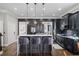 Modern kitchen with dark cabinets, a white countertop island, and stainless steel appliances at 1525 Camden Cove Dr, Cumming, GA 30040