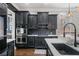 Modern kitchen with dark cabinets, stainless steel appliances, and hardwood floors at 1525 Camden Cove Dr, Cumming, GA 30040