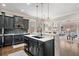 Modern kitchen boasts dark cabinetry, a spacious island, and an open layout to the living area at 1525 Camden Cove Dr, Cumming, GA 30040