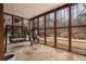 Cozy sunroom area surrounded by floor-to-ceiling windows, a swing and stone floors at 1525 Camden Cove Dr, Cumming, GA 30040