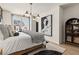 Charming bedroom features a contemporary chandelier, bedside decor, and a large window that provides plenty of natural light at 525 Rubato Knl, Mcdonough, GA 30253