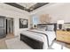 A luxury bedroom features a tray ceiling, a modern chandelier, two large windows, and stylish furniture at 525 Rubato Knl, Mcdonough, GA 30253