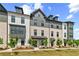 Stylish townhomes displaying brick and siding exteriors, accented by dormer windows and green lawns at 525 Rubato Knl, Mcdonough, GA 30253