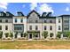 Modern townhome exterior with brick and siding, featuring dormer windows and manicured landscaping at 525 Rubato Knl, Mcdonough, GA 30253