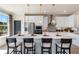 An open-concept kitchen features a large quartz island, stainless steel appliances, and modern pendant lighting at 525 Rubato Knl, Mcdonough, GA 30253