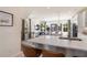 Bright, open kitchen with white cabinets, stainless appliances, bar seating, and dining area with outdoor views at 525 Rubato Knl, Mcdonough, GA 30253
