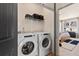 This laundry room features a white washer, a white dryer, and a shelf for storage at 525 Rubato Knl, Mcdonough, GA 30253