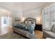 Bright bedroom features a patterned bedspread, matching chair, and large windows with plantation shutters at 1021 Wetherby Way, Alpharetta, GA 30022