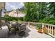 Outdoor deck features a dining table with an umbrella and wooded backyard view at 1021 Wetherby Way, Alpharetta, GA 30022