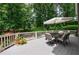 Outdoor deck features a dining table with an umbrella and wooded backyard view at 1021 Wetherby Way, Alpharetta, GA 30022