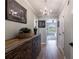 Bright hallway with stylish wooden cabinet, chandelier and doorway leading to a sunny living area at 1021 Wetherby Way, Alpharetta, GA 30022