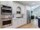 Updated kitchen with stainless steel appliances, a built-in oven, and white cabinetry at 1021 Wetherby Way, Alpharetta, GA 30022