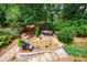 Aerial view of a backyard patio with a hot tub surrounded by lush landscaping at 1021 Wetherby Way, Johns Creek, GA 30022