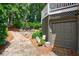 View of a garage door in a home with a stone walkway, and lush landscaping at 1021 Wetherby Way, Johns Creek, GA 30022