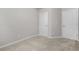 A carpeted bedroom showcasing two white doors and neutral paint at 3181 Meadowstone Sw Ln, Atlanta, GA 30331