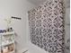 Clean and stylish bathroom featuring a patterned shower curtain and convenient shelving for essential items at 3255 Morgan Rd, Buford, GA 30519