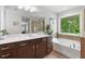 Bathroom featuring separate tub, shower, dark wood vanity, and window at 3255 Morgan Rd, Buford, GA 30519