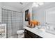 Well-lit bathroom with a modern vanity, stylish mirror, floral accents, and a shower featuring a patterned curtain at 3255 Morgan Rd, Buford, GA 30519
