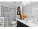 Well-lit bathroom featuring a marble countertop, decorative mirror, and patterned shower curtain at 3255 Morgan Rd, Buford, GA 30519