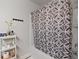 Well-lit bathroom features a shower with patterned curtain and a convenient storage shelf at 3255 Morgan Rd, Buford, GA 30519