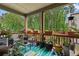 Relax on this beautiful covered porch, surrounded by potted plants, offering a serene view of the lush, wooded backyard at 3255 Morgan Rd, Buford, GA 30519
