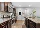 Kitchen features stainless appliances, dark wooden cabinets, granite counters and a center island with barstool seating at 3255 Morgan Rd, Buford, GA 30519